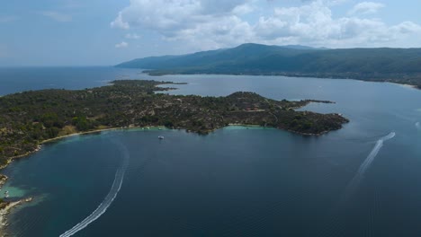 Clip-Giratorio-De-Drones-Sobre-Una-Isla-Tropical-En-La-Bahía-De-Vourvourou,-Halkidiki,-Norte-De-Grecia