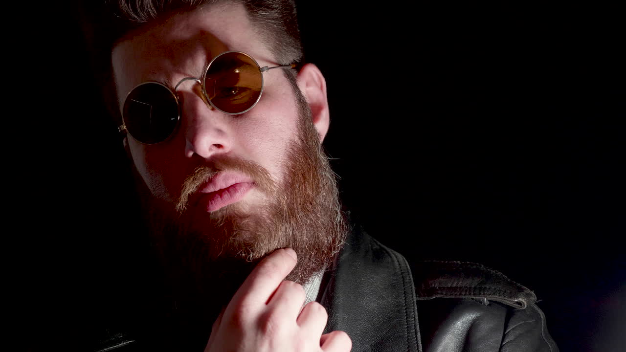 Man with beard and round sunglasses