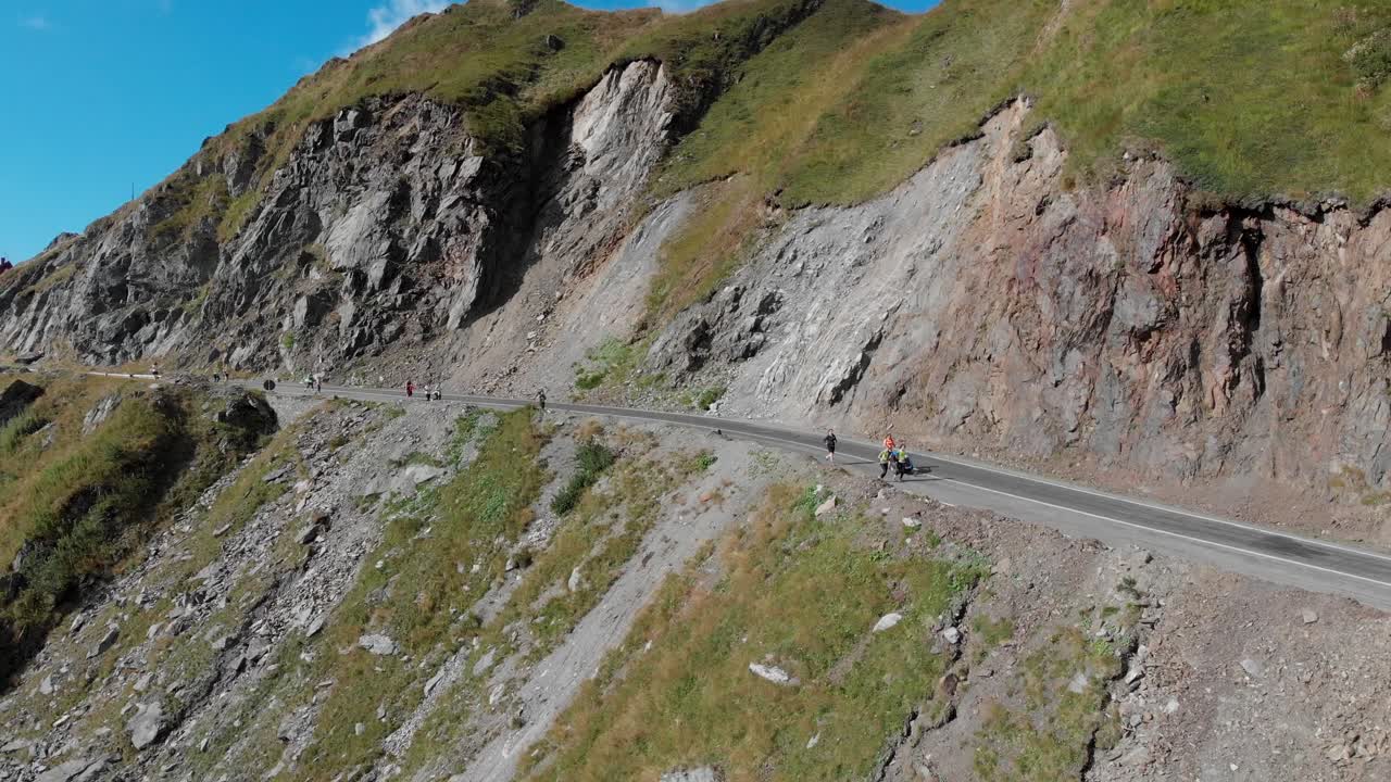 루마니아의 산악 도로에서 달리는 한 무리의 사람들의 멀리 떨어진 샷