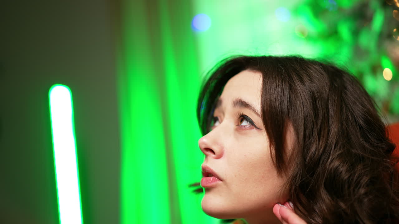 Attractive Caucasian brunette woman sits indoors. Portrait of a pensive lady close up.