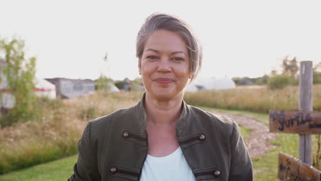 Retrato-De-Una-Mujer-Madura-Sonriente-Visitando-Un-Camping-De-Yurtas-En-El-Campo