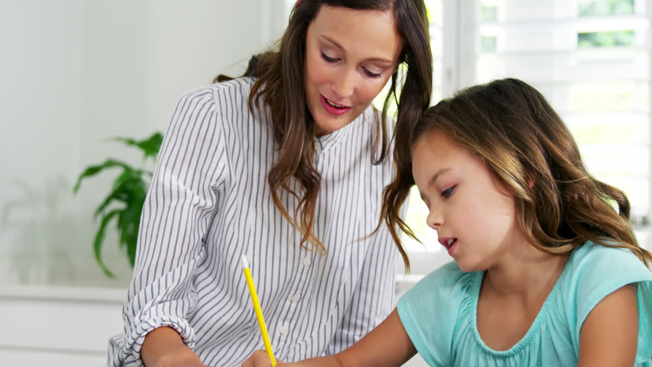 madre ayudando a su hija con los deberes escolares