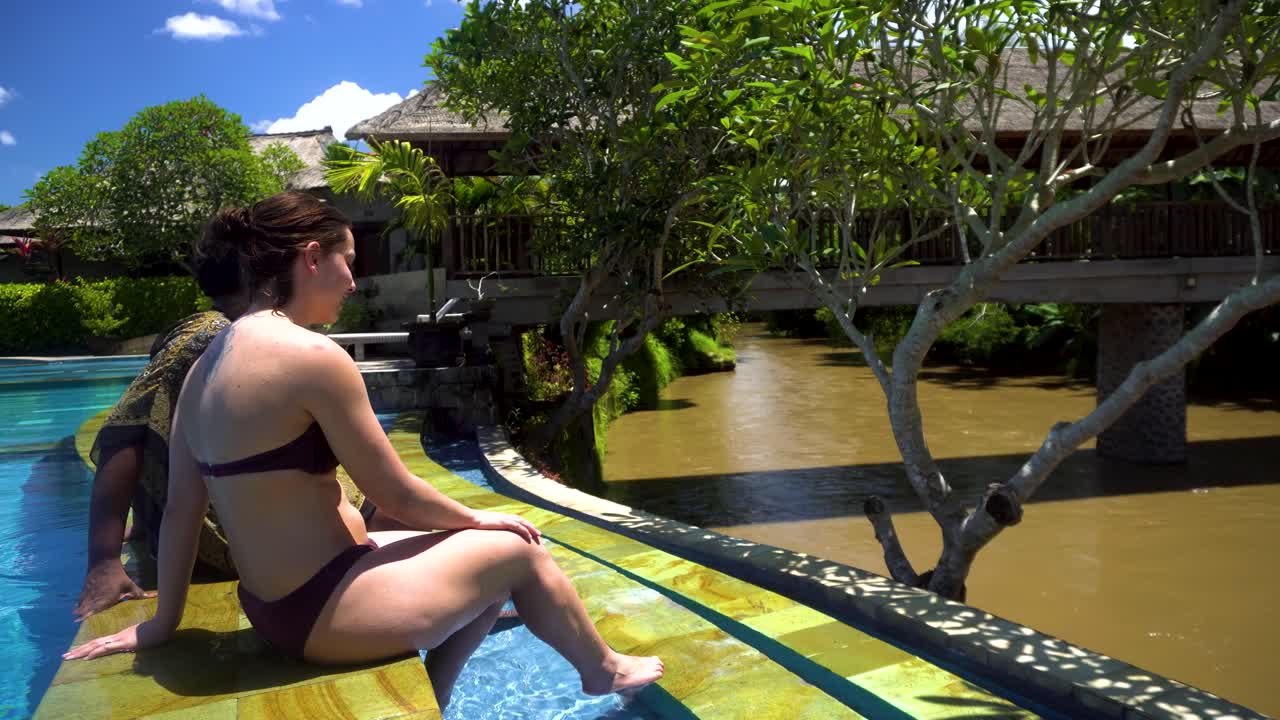 Two women relaxing by a pool in Bali