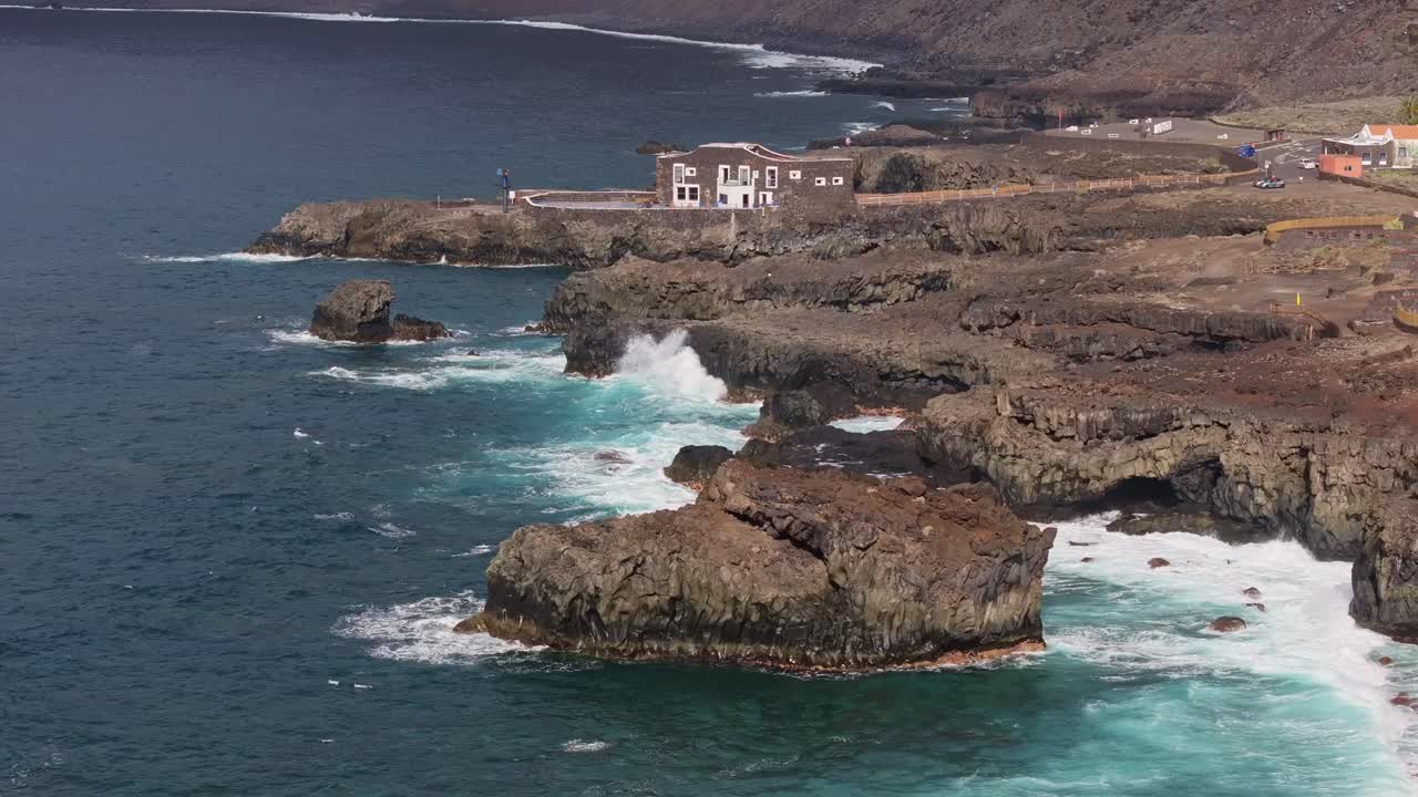 Sunlit cliffs, turquoise waves on El Hierro’s volcanic north coast, slowly