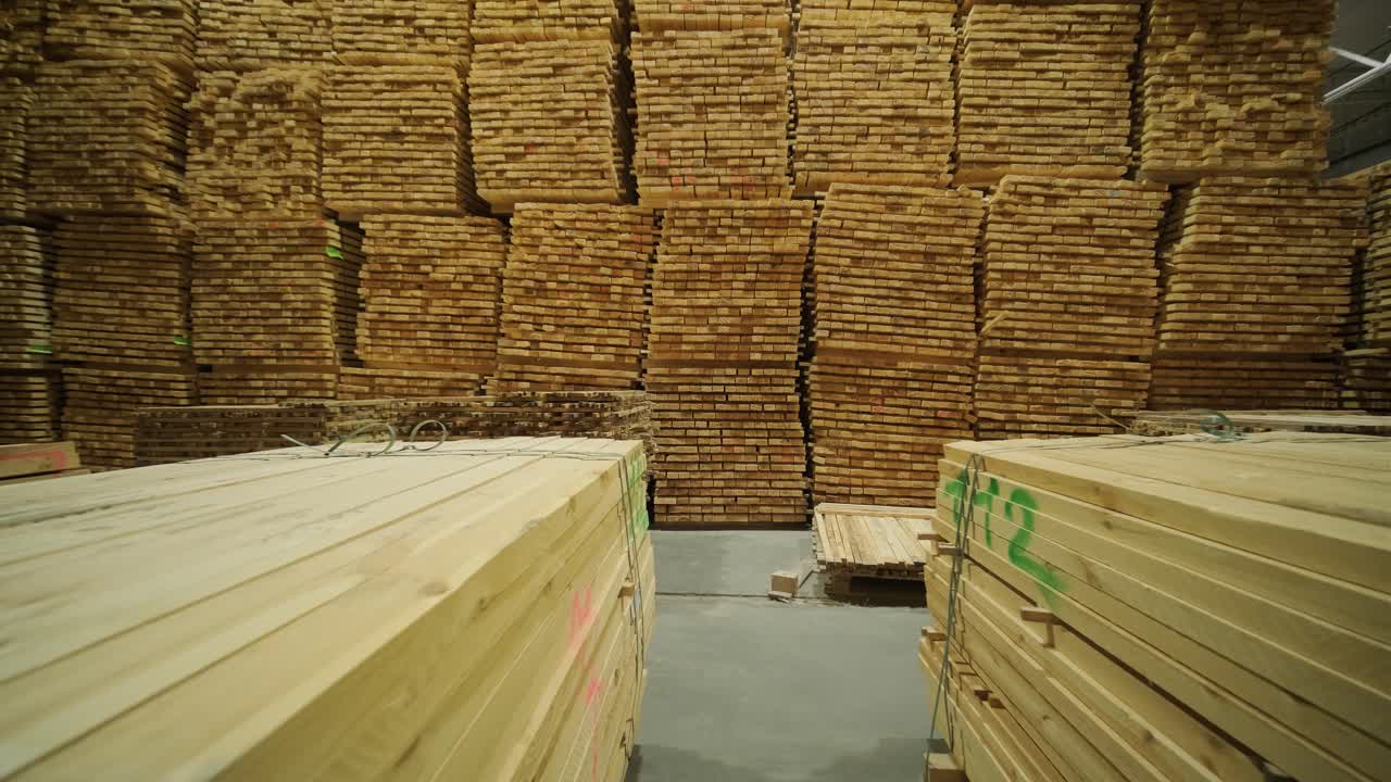 Dolly Shot Through a Warehouse with Large Stacks of Lumber