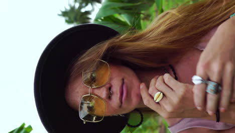 Close-up-of-face-of-a-young-Caucasian-woman-playing-with-her-hands-in-a-forest-background