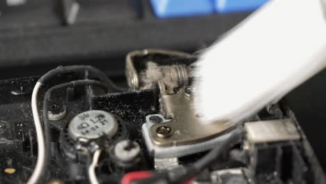 repair of an old laptop, the technician cleans the interior using a brush