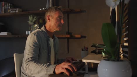 man using computer at home at night