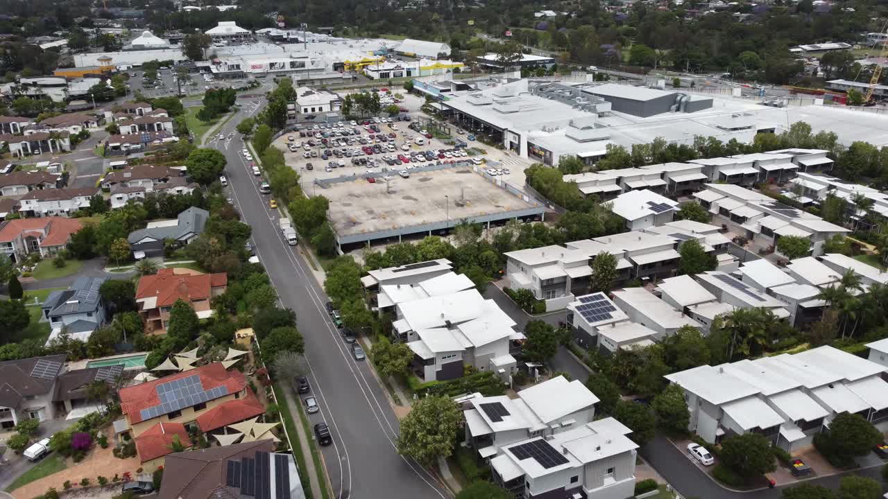 Drone descending over a residential area in Australia with a shopping centre near by