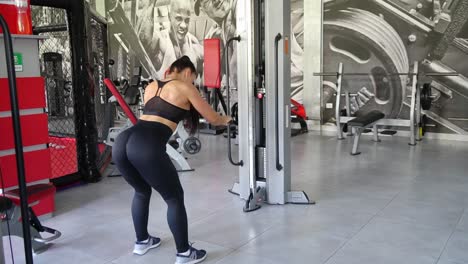 sporty woman exercising on multistation at gym for arm and shoulders muscles. fitness exercising in gym. the girl works out and trains her shoulders with a cross trainer in the gym