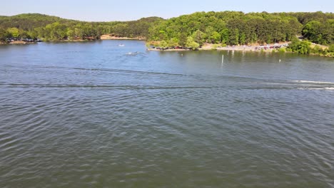 barco de wakeboard cruzando el lago con estela detrás
