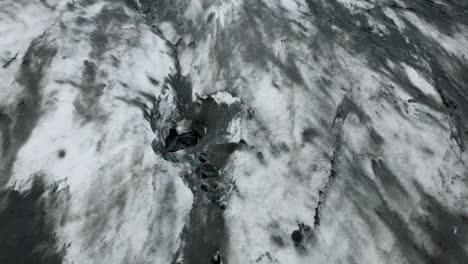 A-glacier-in-iceland,-showcasing-rugged-terrain-and-icy-landscape,-aerial-view