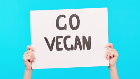 hands, poster and vegan propaganda on a blue