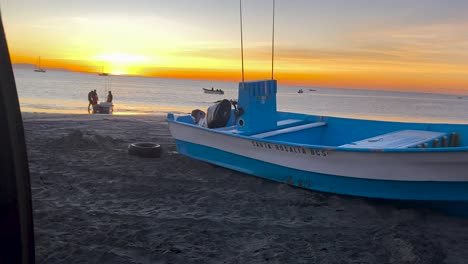 Gorgeous-yellow-orange-sunset-view-of-fishing-boat-on-beach