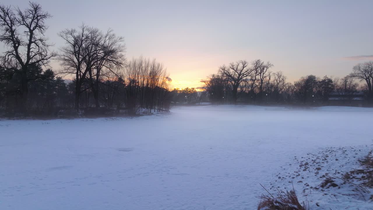 눈이 인 숲이 가득한 은행과 공원 위의 공중 도리 태양이 떠오르면서 신비로운 안개에 빛을 비추고 있습니다.
