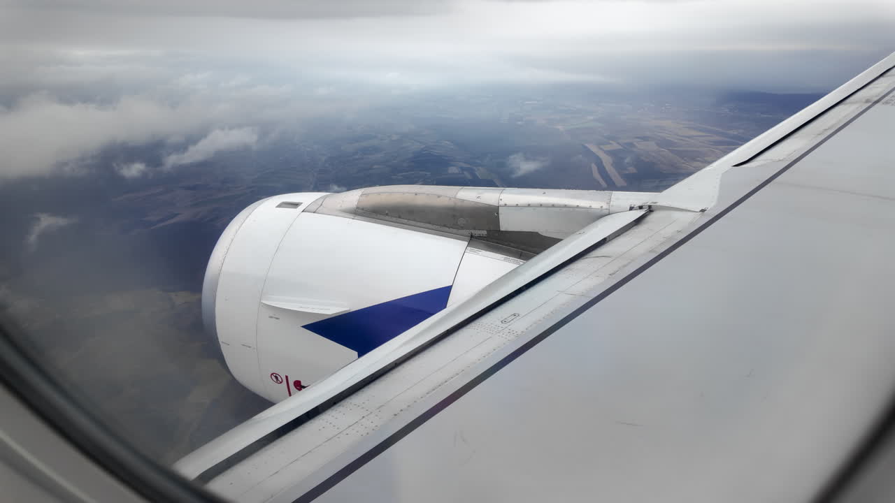 View from an airplane window of houses and fields while a plane is preparing to land