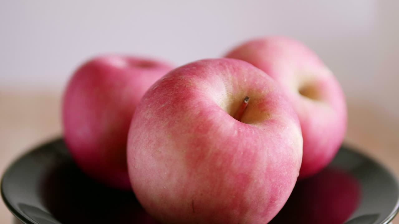 회전하는 표면에 있는 다채로운 맛있는 사과 쇼케이스는 밝은 붉은 색을 띠고 매우 맛있어 보입니다.