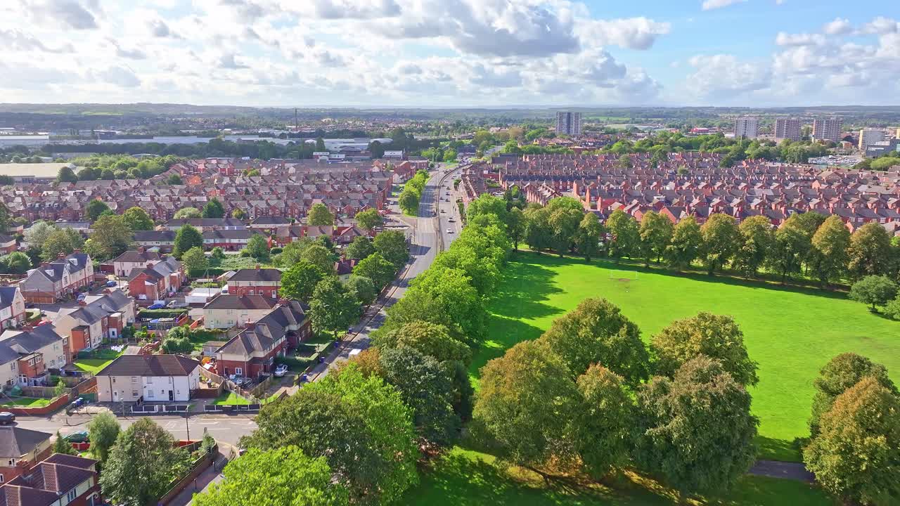 Ett livfullt grönt fält kantat av träd vid kanten av villor med röda tak i Doncaster, England.