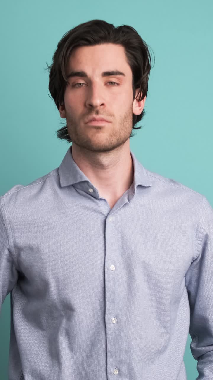 Stunned man with opened mouth in blue studio