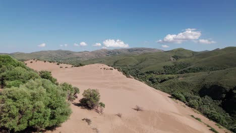 sandy slope dips below into deep grassy valley on island of lemnos, aerial overview