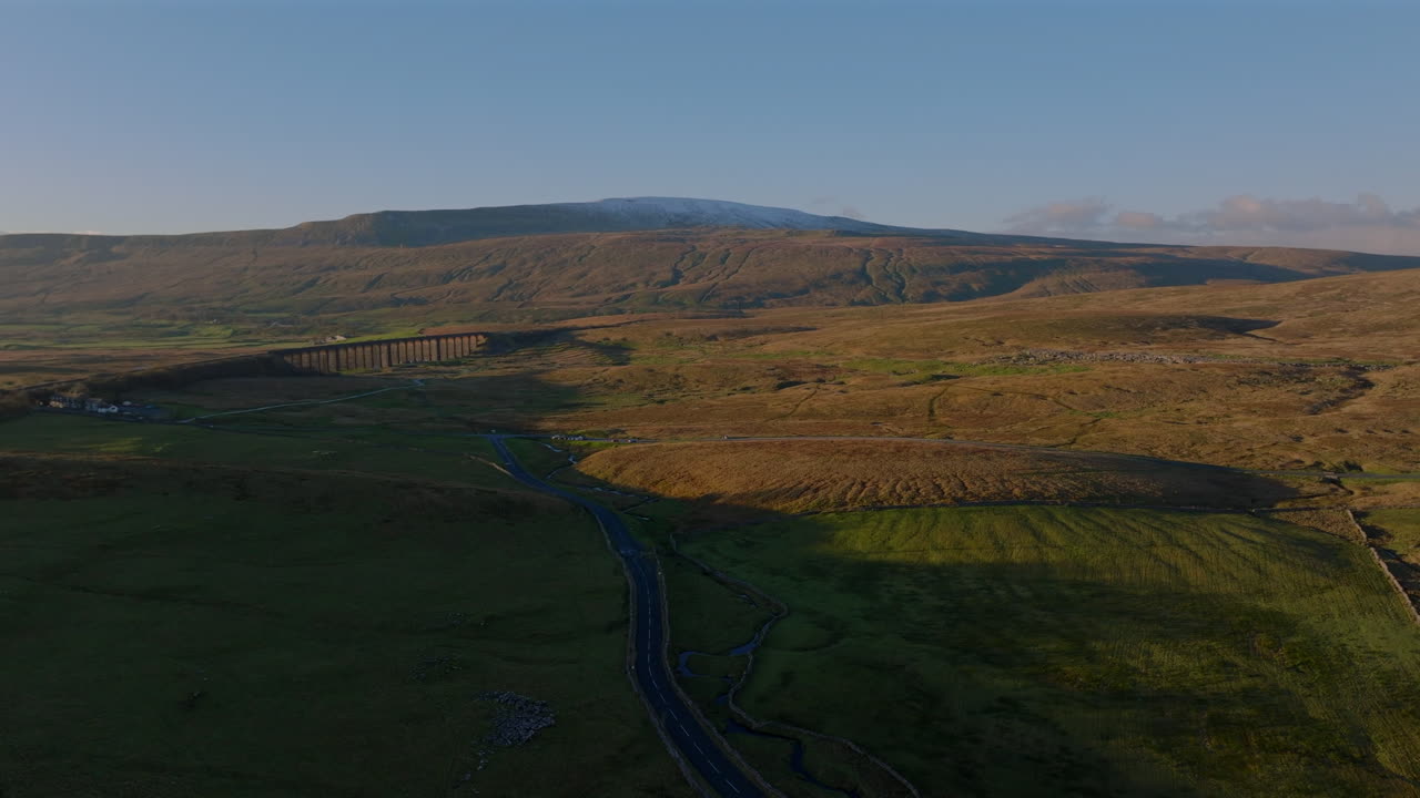 tomada de un dron de gran ángulo del viaducto de ribblehead y la nevada puesta de sol de whernside