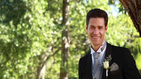 Handsome-groom-smiling-at-camera