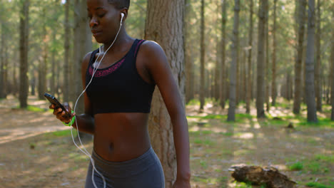 Female-jogger-using-mobile-phone-while-jogging-4k