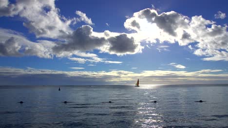 silhouetted sailboat under blue skies