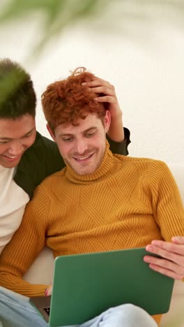 happy lgbtq+ couple sharing a moment with a laptop