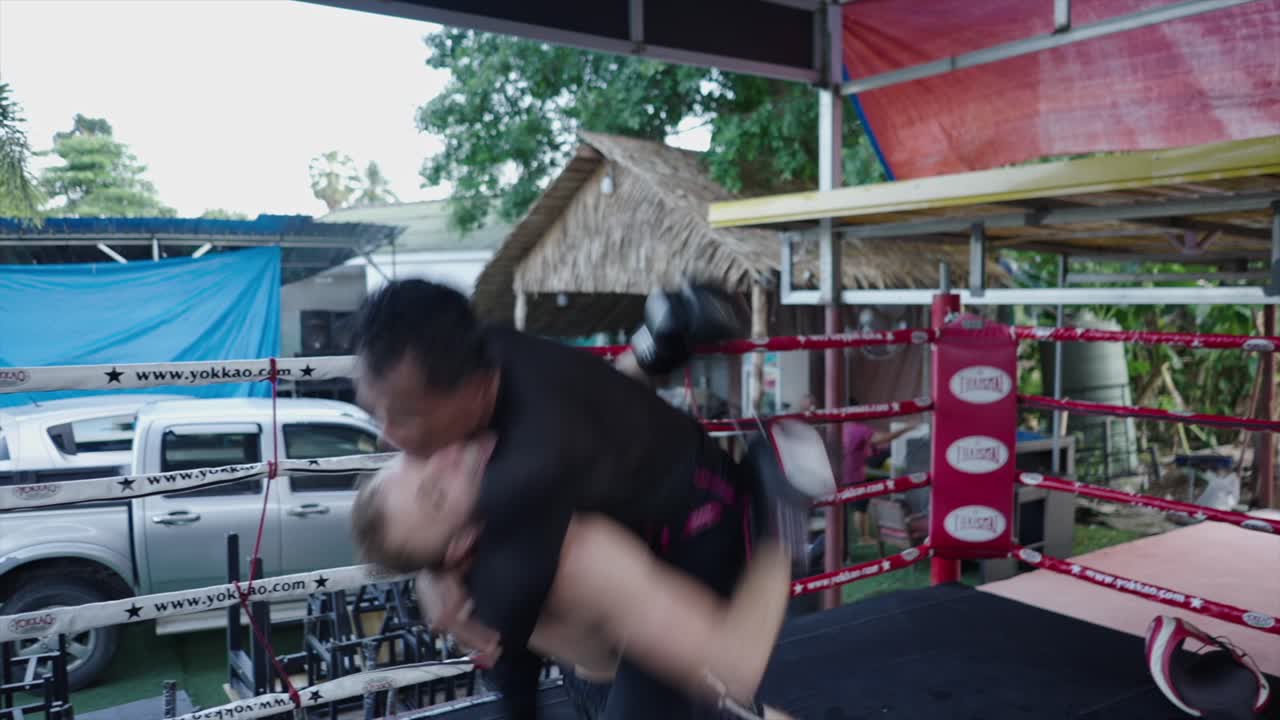 Two Men Grappling During a Muay Thai Sparring Session