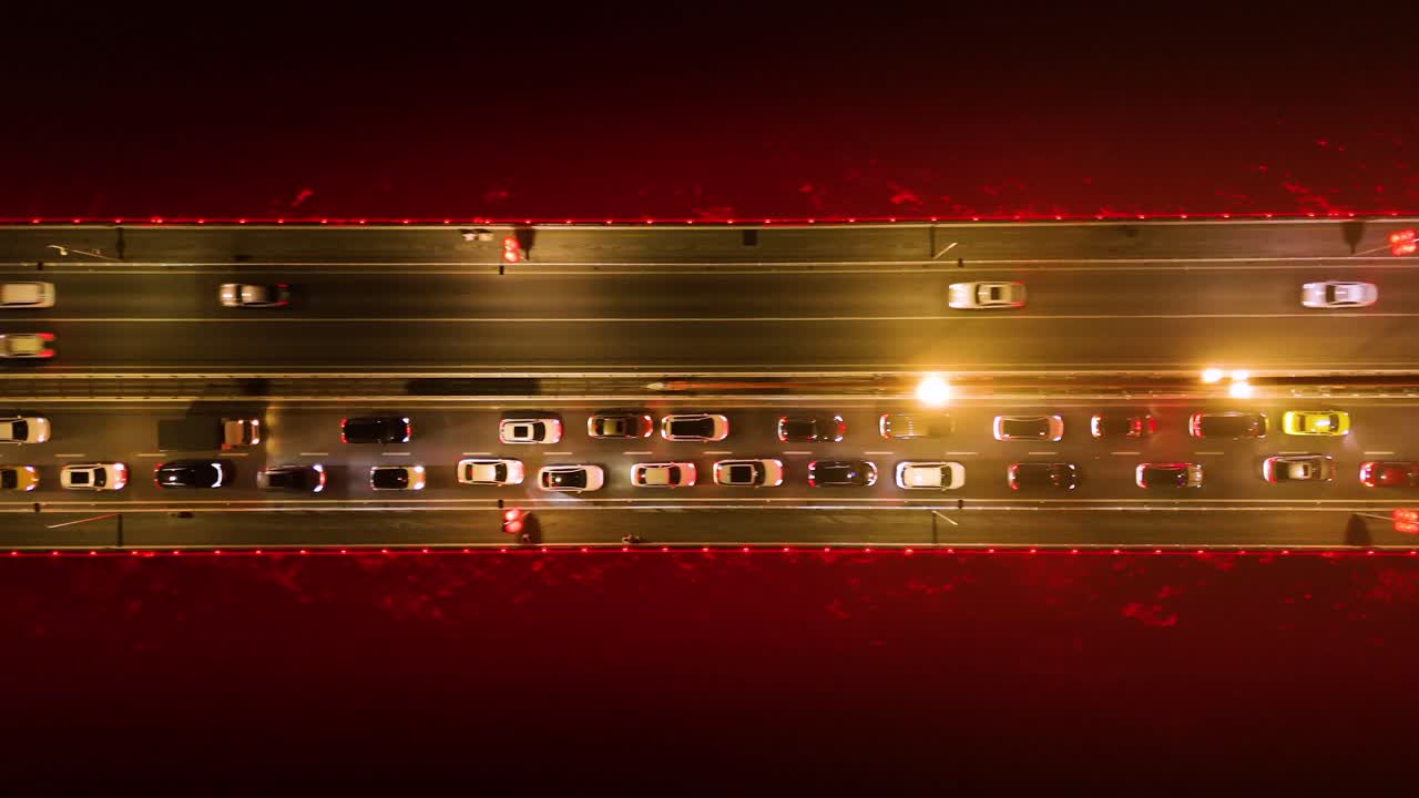 Top-down drone shot of Twin River Bridges with cars above Yangtze River at night in Chongqing, Yuzhong District, China