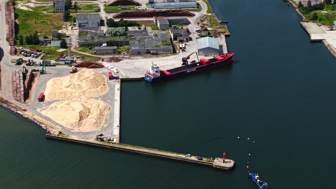 An aerial view captures a cargo ship docked at a port