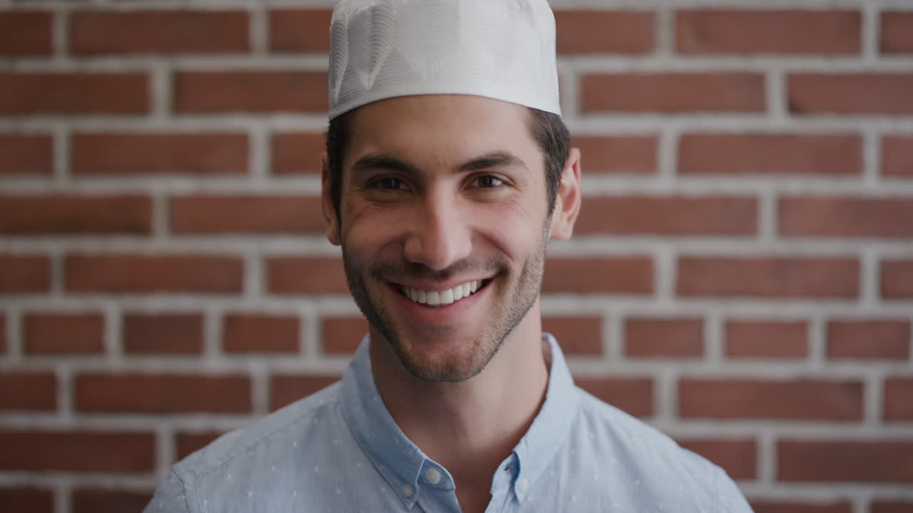 ritratto attraente giovane uomo musulmano sorridente che gode di uno stile di vita di successo uomo felice e indipendente che indossa un cappello kufi in rallentatore