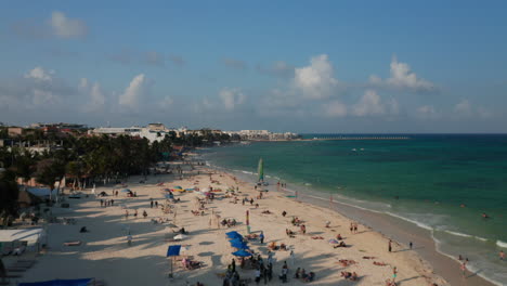 Aerial-view-with-sunbathing-tourists-on-sandy-beach-along-the-Carribean-Sea-shoreline-at-Playa-del-Carmen