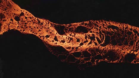 Aerial-drone-descendent-over-river-of-glowing-lava