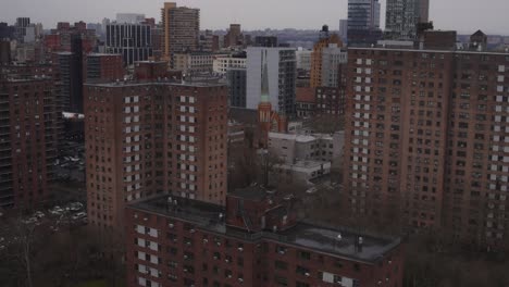 schuss von backstein-büro- und wohngebäuden auf die straße in new york city, von einem dach an einem trüben regnerischen tag.