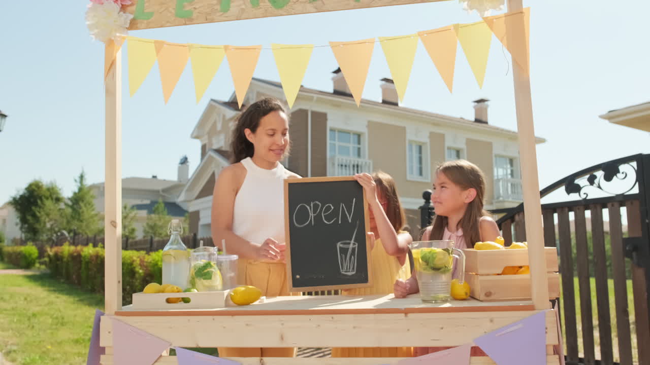 Mom And Two Girls With Open Sign At Lemonade Market