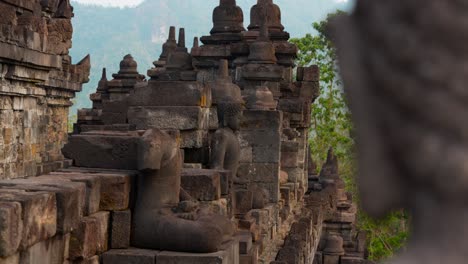 left parallax glide at borobudur reveals buddha statues and relief carvings in shallow depth of field, highlighting ancient buddhist architecture in central java, indonesia