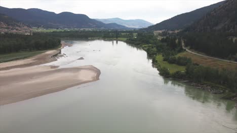 Scenic-aerial-Pan-of-the-South-Thompson-River-close-to-Kamloops-in-British-Columbia-Canada-,-with-sandy-beaches,-pine-forests-and-a-View-on-Shuswap-Road