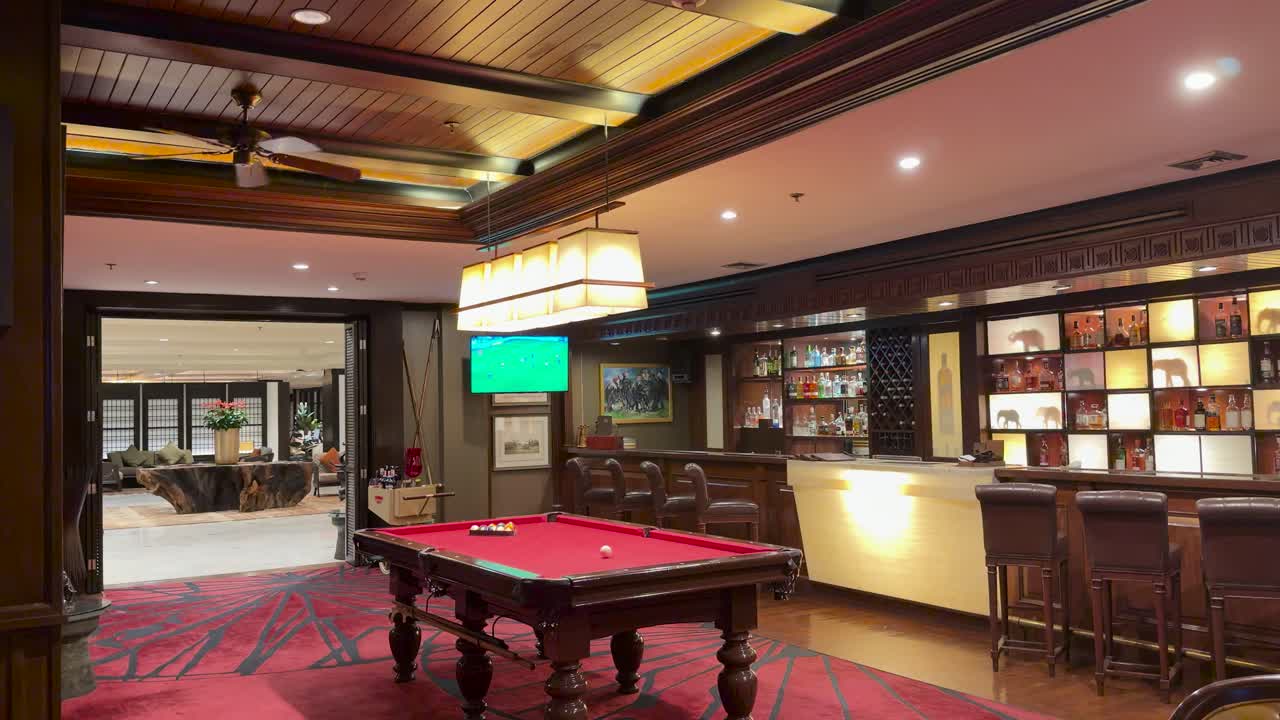 Elegant hotel bar and billiards area, warm lighting, static camera, evening leisure atmosphere, Bangkok location