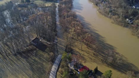 aerial top down view of river overflowing closing the street and road in american neighborhood