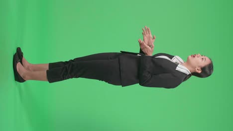 full body side view of asian businesswoman in suit jacket standing and presenting something on the green screen background