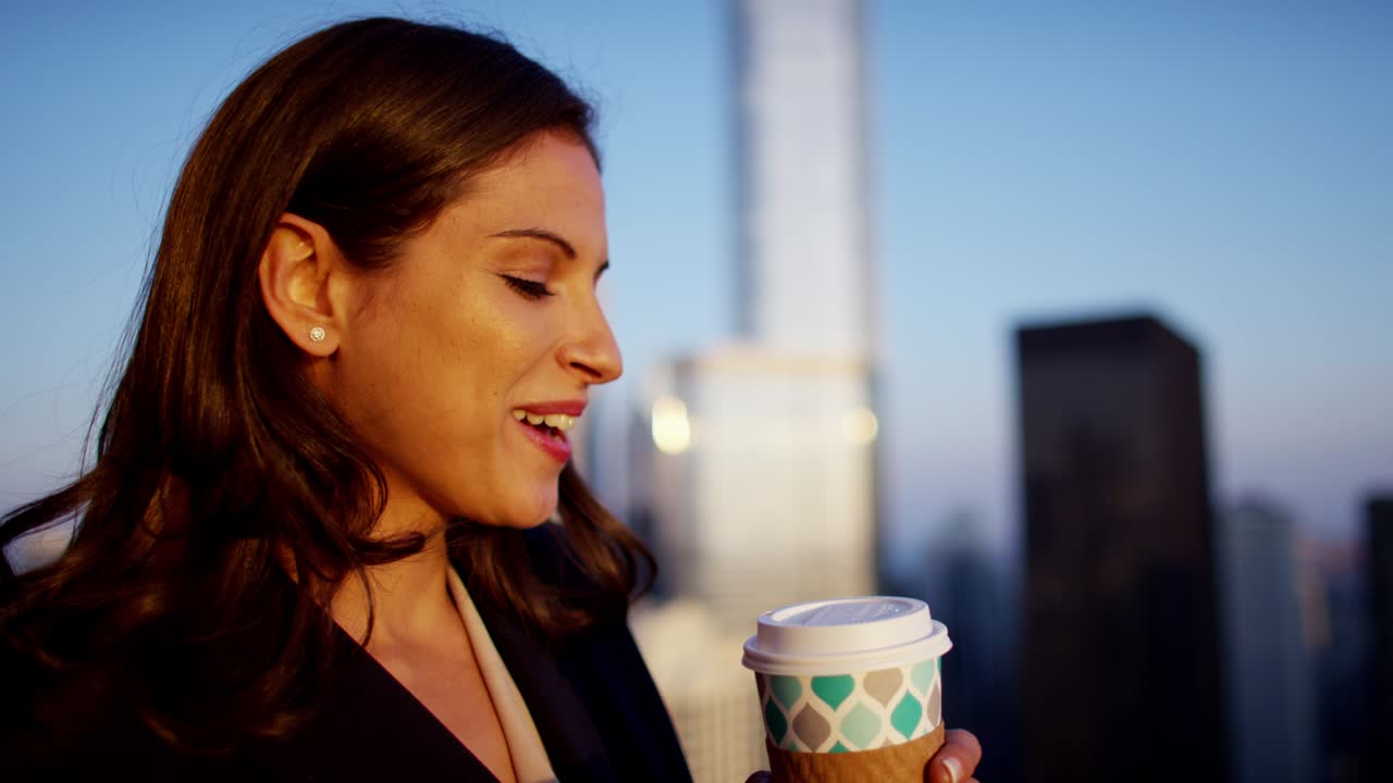 una mujer de negocios hispana usando un teléfono inteligente en el techo al amanecer