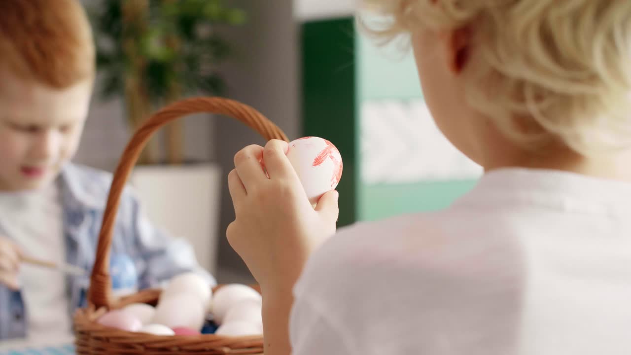 Close up of boy painting easter egg