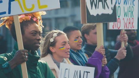 group of protestors with placards on ukrainian anti war demonstration march