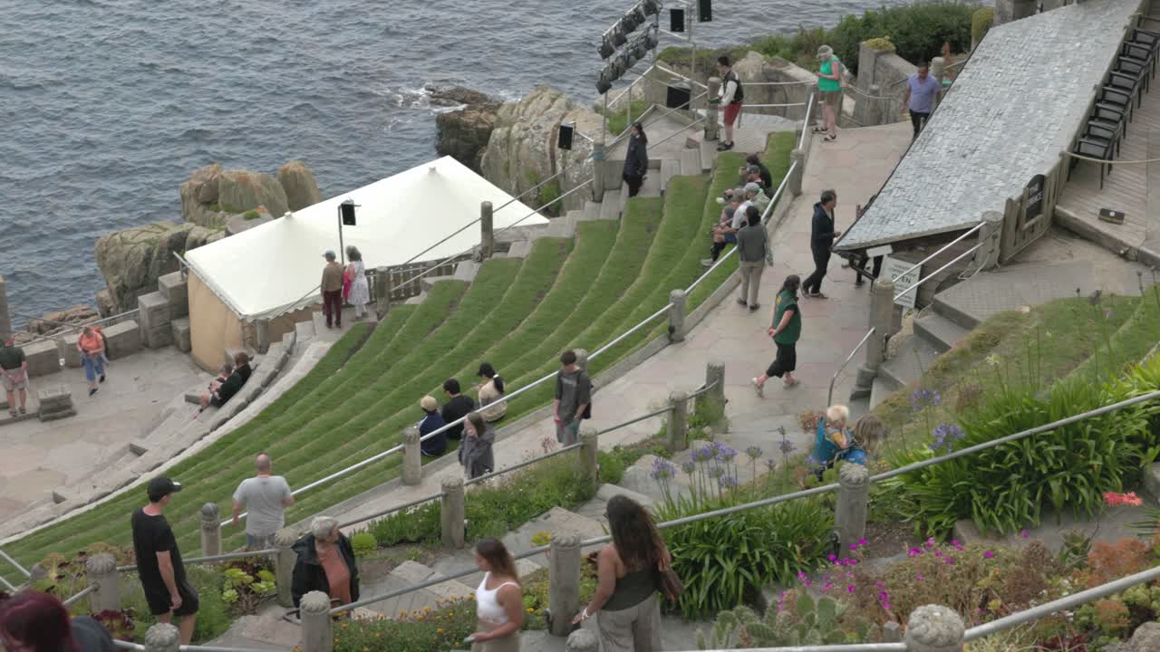 People visiting an outdoor amphitheater by the ocean