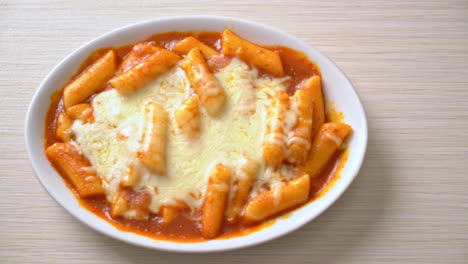 pastel de arroz coreano en salsa coreana picante con queso, tokpokki de queso, tteokbokki con queso - estilo de comida coreana