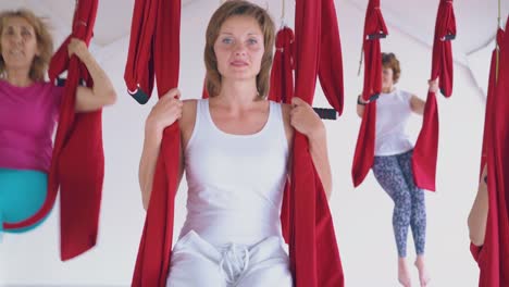 lady wearing white sport suit relaxes after fly yoga workout