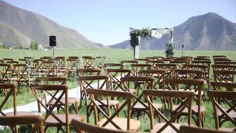 lugar para bodas al aire libre, asientos y arco floral con fondo de montaña