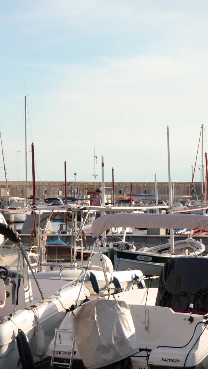 Statische Weitwinkelaufnahme von weißen Motorbooten, die in einem französischen Hafen bei hellem Tageslicht vertäut sind
